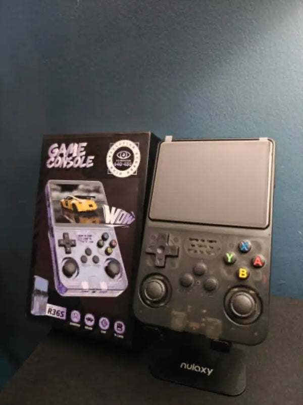 Console noire translucide posée sur un support de bureau, à côté de sa boîte